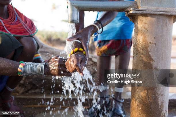 women collecting clean water from borehole in desert. samburu. kenya. - borehole stock-fotos und bilder