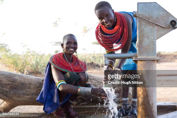 women collecting clean water from borehole in desert. samburu. kenya. - hugh sitton fotografías e imágenes de stock