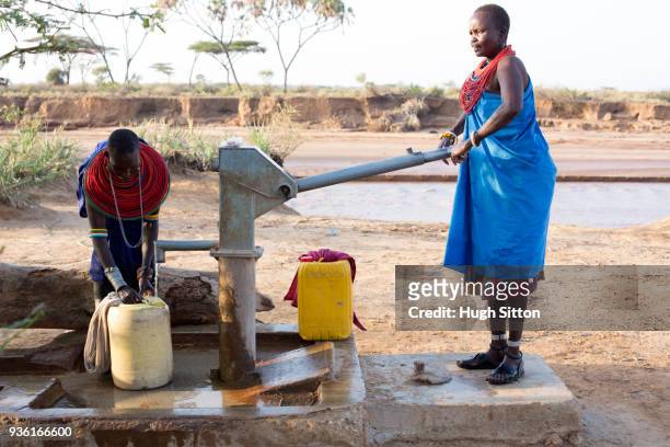 women collecting clean water from borehole in desert. samburu. kenya. - hugh sitton stock pictures, royalty-free photos & images