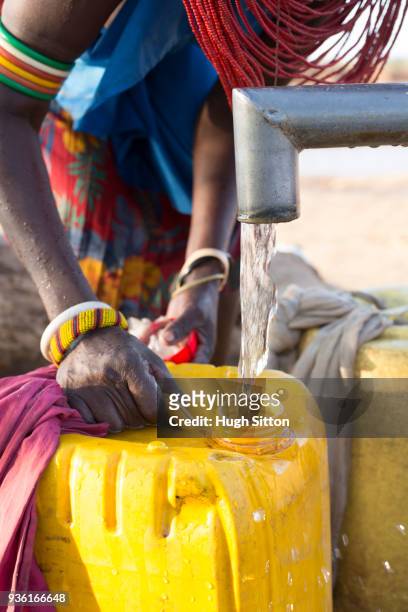 women collecting clean water from borehole in desert. samburu. kenya. - hugh sitton fotografías e imágenes de stock