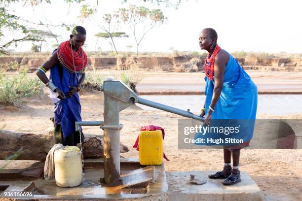 women collecting clean water from borehole in desert. samburu. kenya. - hygiene stockfoto's en -beelden