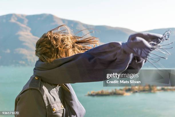 woman with moving hair and scarf in sunlight in a windy day - halstuch stock-fotos und bilder