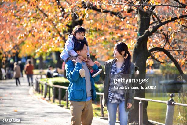 japanese family relaxing in ueno park, tokyo - park couple piggyback stock pictures, royalty-free photos & images