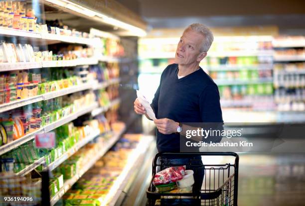 senior man goes grocery shopping. - boodschappenlijst stockfoto's en -beelden