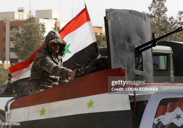 Member of the Syrian regime forces sits in an armed vehicle at the entrance of Harasta in Eastern Ghouta, on the outskirts of Damascus, on March 22...