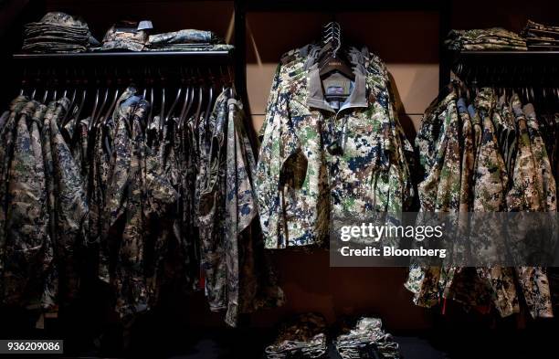 Sitka camouflaged hunting clothes hang on display inside the Joh. Springer's Erben Handels rifle and hunting supplies store in Vienna, Austria, on...