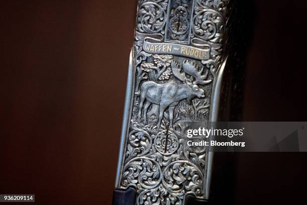 An artisanal repeating rifle featuring the engraving of a moose stands on display inside the Joh. Springer's Erben Handels rifle and hunting supplies...