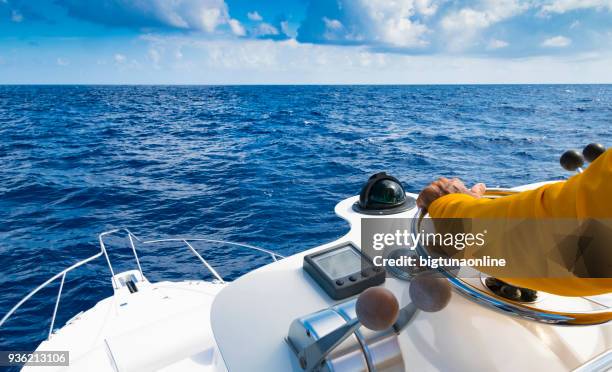 Hand of captain on steering wheel of motor boat in the blue ocean during the fishery day. Success fishing concept. Ocean yacht