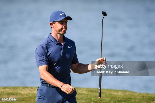 Rory McIlroy of Northern Ireland celebrates and raises his putter after making a long birdie putt on the 14th hole green during round one of the...