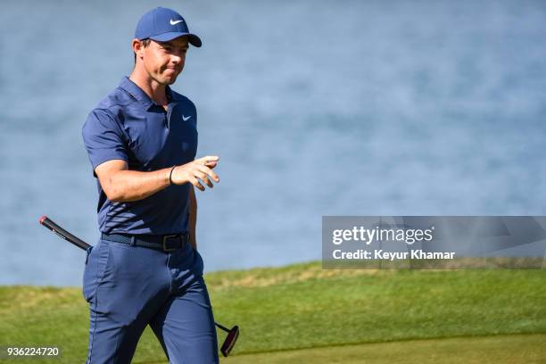 Rory McIlroy of Northern Ireland celebrates and raises his putter after making a long birdie putt on the 14th hole green during round one of the...