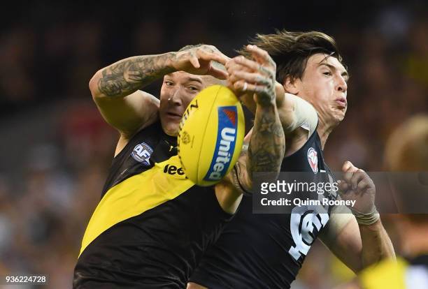 Dustin Martin of the Tigers marks infront of Caleb Marchbank of the Blues during the round one AFL match between the Richmond Tigers and the Carlton...
