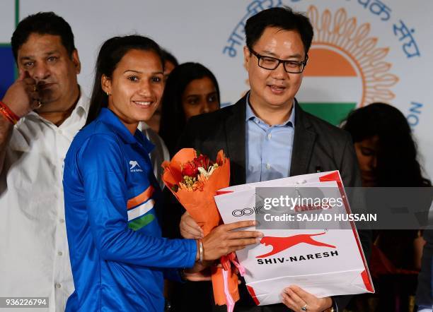 Indian women hockey team captain Rani Rampal receives a bouquet of flowers from Union Minister of State for Home Affairs of India Kiren Rijiju during...