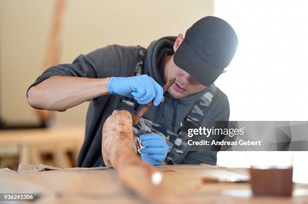 Museum worker prepares a bone of a representation of what museum officials claim is the world's biggest discovered winged dinosaur prior to its...