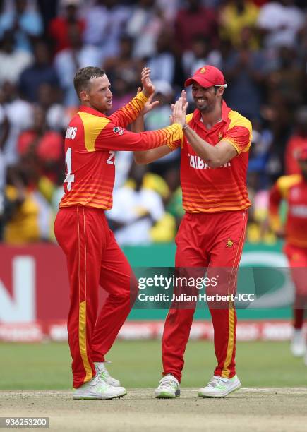 Sean Williams and Graeme Cremer of Zimbabwe celebrate the wicket of Muhammad Usman of the UAE during The ICC Cricket World Cup Qualifier between the...