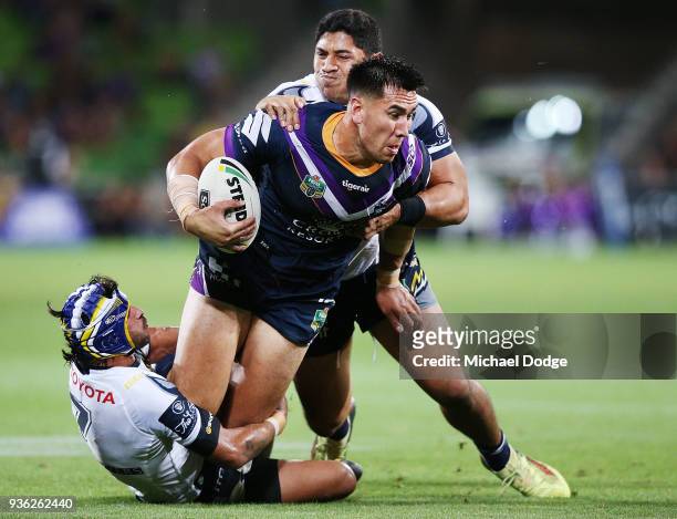 Johnathan Thurston of the Cowboys and John Asiata tackle Nelson Asofa Solomona of the Storm gets tackled during the round three NRL match between the...