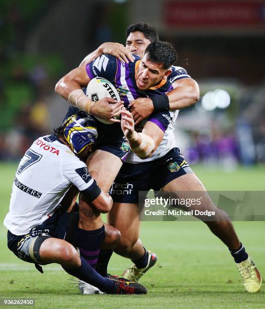 Johnathan Thurston of the Cowboys and John Asiata tackle Nelson Asofa Solomona of the Storm gets tackled during the round three NRL match between the...