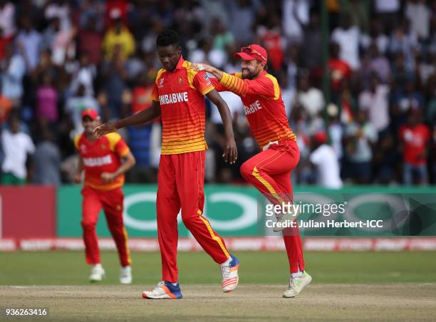 Blessing Muzarabani and Sean Ervine of Zimbabwe celebrate the wicket of Ahmed Raza of the UAE during The ICC Cricket World Cup Qualifier between the...