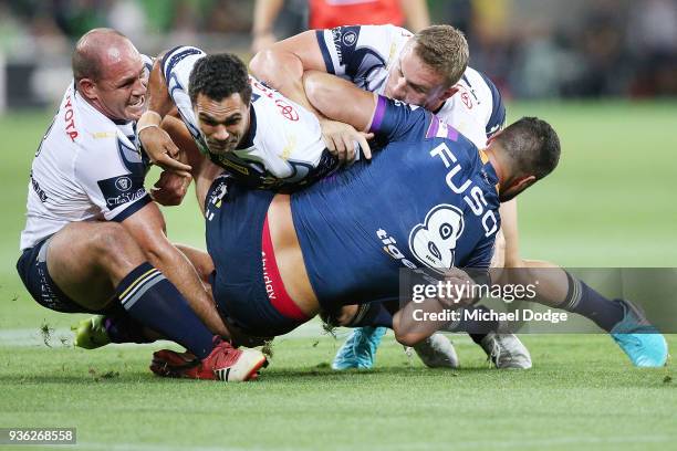 Matthew Scott Justin O'Neill and Coen Hess of the Cowboys tackles Jesse Bromwich of the Storm during the round three NRL match between the Melbourne...