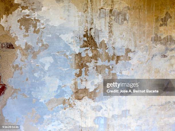 wall with peeling blue and white paint with cracks and dampness. high resolution photography. - adobe texture stockfoto's en -beelden