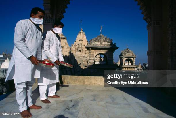 India, Gujarat, Palitana, Jain pilgrims with offerings of flowers at Shatrunjaya or Place of Victory hilltop temple complex and historic Jain...