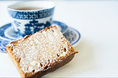 close up traditional Dutch spiced caked called ontbijtkoek or peperkoek. cup of tea, coffee white background. space for text