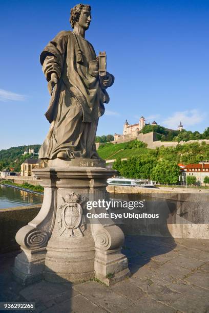 Germany, Bavaria, Wurzburg, Festung Marienberg above the River Main with a statue of St Totnan on Alte Mainbrucke.