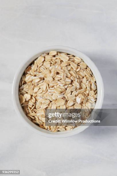 overhead view of oats in bowl - oat stockfoto's en -beelden