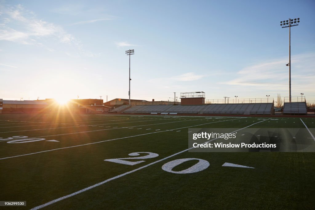 Forty yard line on green playing field at sunset