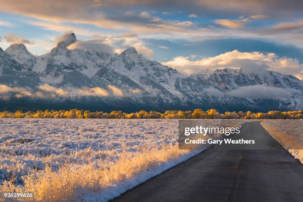 usa, wyoming, country road and teton range at sunset - wyoming stock pictures, royalty-free photos & images