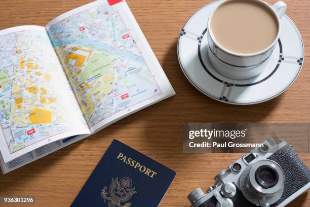 passport, coffee, old camera and open guidebook - guide touristique photos et images de collection