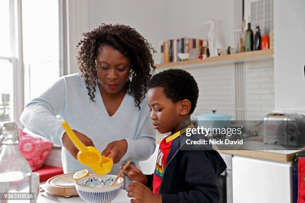 mother and son (4-5) baking in kitchen - mature woman and son imagens e fotografias de stock