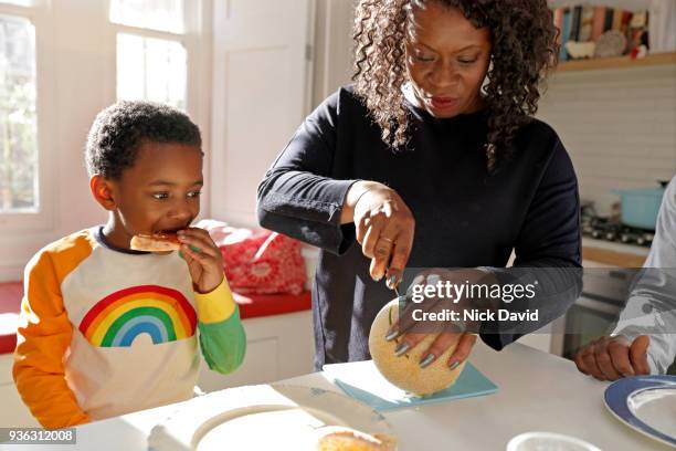 mother and son (4-5) in kitchen - black mother and child cooking stock-fotos und bilder