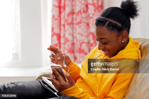 teenage girl (14-15) relaxing with smartphone at home - girl black hair room stock pictures, royalty-free photos & images