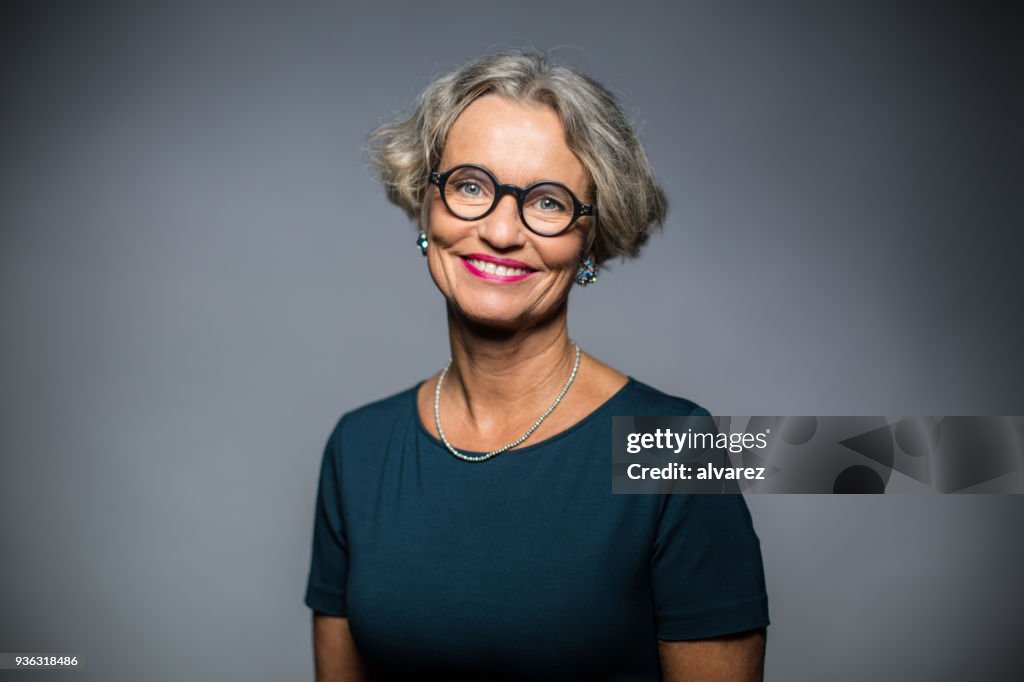 Ritratto di donna felice su sfondo grigio