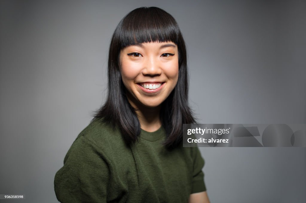 Retrato de mujer alegre contra el fondo gris