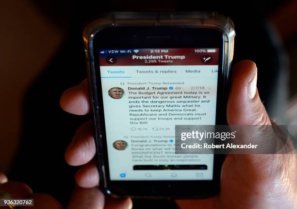 Man reads a tweet from Donald Trump on his smartphone in Santa Fe, New Mexico.