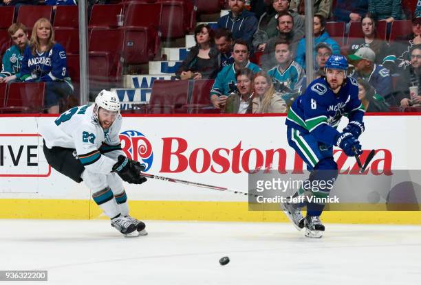 Barclay Goodrow of the San Jose Sharks and Christopher Tanev of the Vancouver Canucks watch a loose puck during their NHL game at Rogers Arena March...
