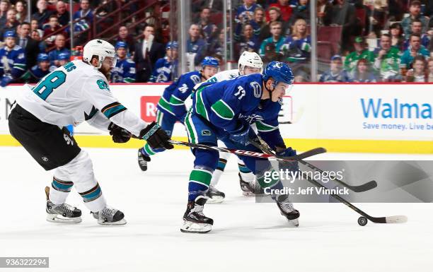 Brent Burns of the San Jose Sharks checks Nikolay Goldobin of the Vancouver Canucks during their NHL game at Rogers Arena March 17, 2018 in...