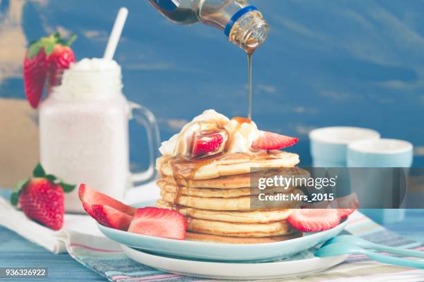 pouring syrup onto a stack of pancakes with fresh strawberries - strawberry milkshake and nobody stock pictures, royalty-free photos & images