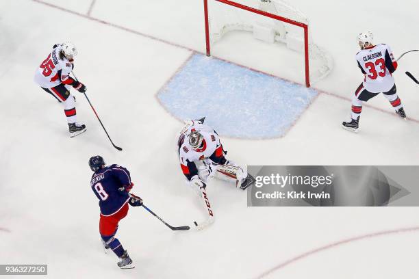 Mike Condon of the Ottawa Senators knocks the puck away from Zach Werenski of the Columbus Blue Jackets during the game on March 17, 2018 at...