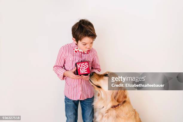 boy blowing a kiss to his golden retriever dog - european best pictures of the day february 14 2018 bildbanksfoton och bilder