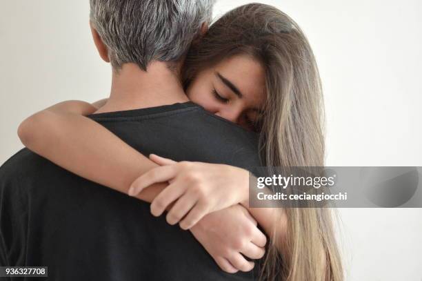 teenage girl hugging her father - father daughter stock pictures, royalty-free photos & images