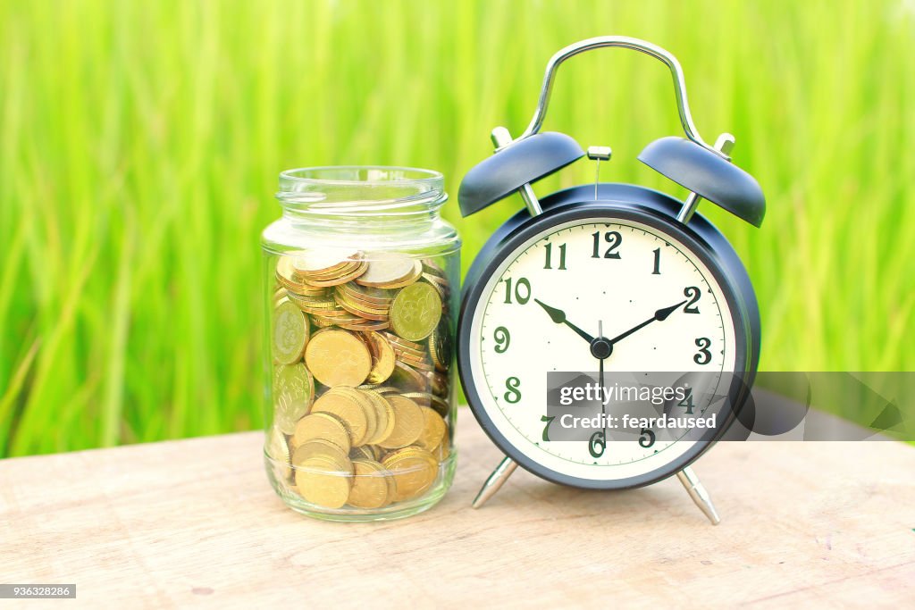 Alarm clock on a table next to a jar