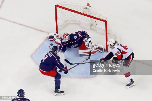 Jack Johnson of the Columbus Blue Jackets defends as Sergei Bobrovsky of the Columbus Blue Jackets stops a shot from Erik Karlsson of the Ottawa...