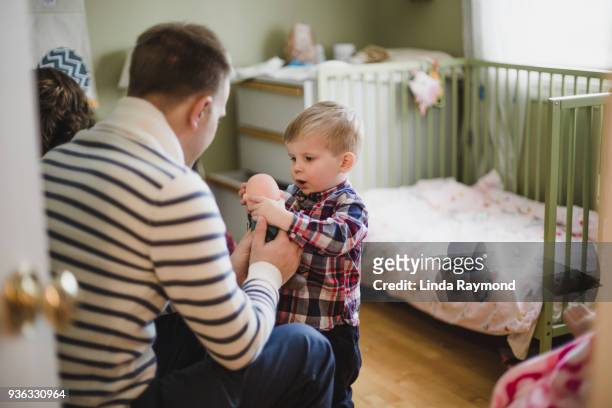 far och son leker med en docka - doll bildbanksfoton och bilder