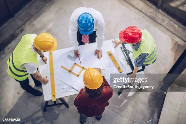 architecten samen te werken op de bouwplaats - construction planning stockfoto's en -beelden