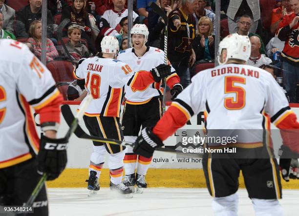 Dougie Hamilton of the Calgary Flames celebrates with teammate Matt Stajan after scoring a goal against the Arizona Coyotes at Gila River Arena on...