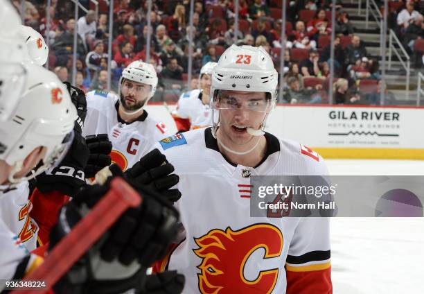 Sean Monahan of the Calgary Flames celebrates with teammates on the bench after scoring a goal against the Arizona Coyotes at Gila River Arena on...