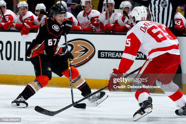 Rickard Rakell of the Anaheim Ducks skates with the puck against Danny DeKeyser of the Detroit Red Wings during the game on March 16, 2018 at Honda...