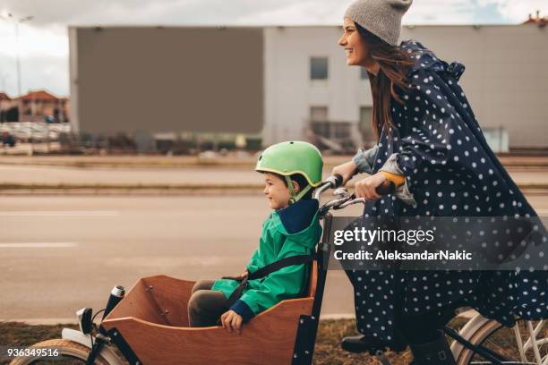 母と息子の貨物のバイクに乗って - raincoat ストックフォトと画像